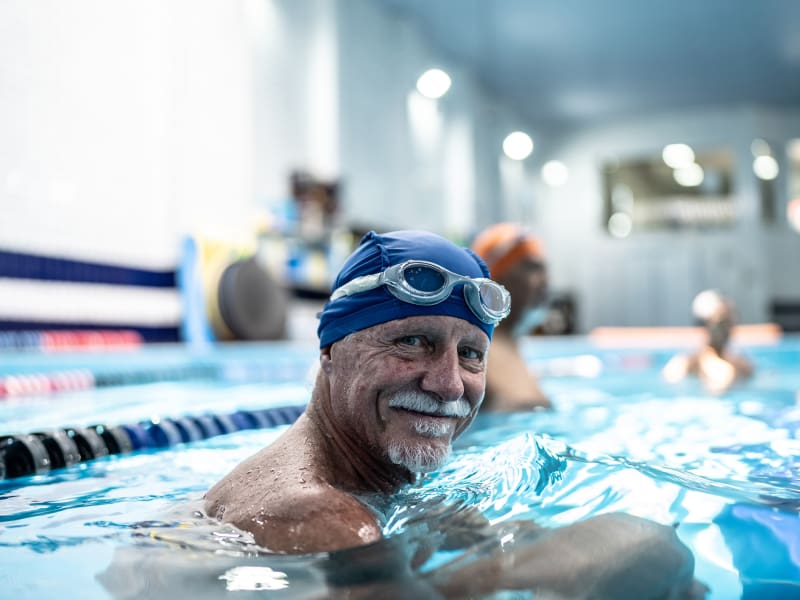 Man in his 60s swimming laps in an indoor pool