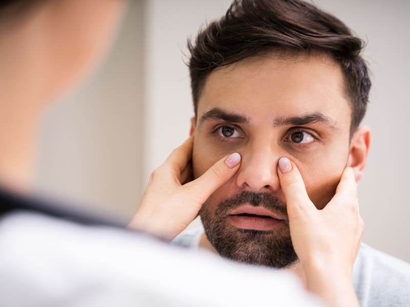 Doctor examining a male patient's nasal passage